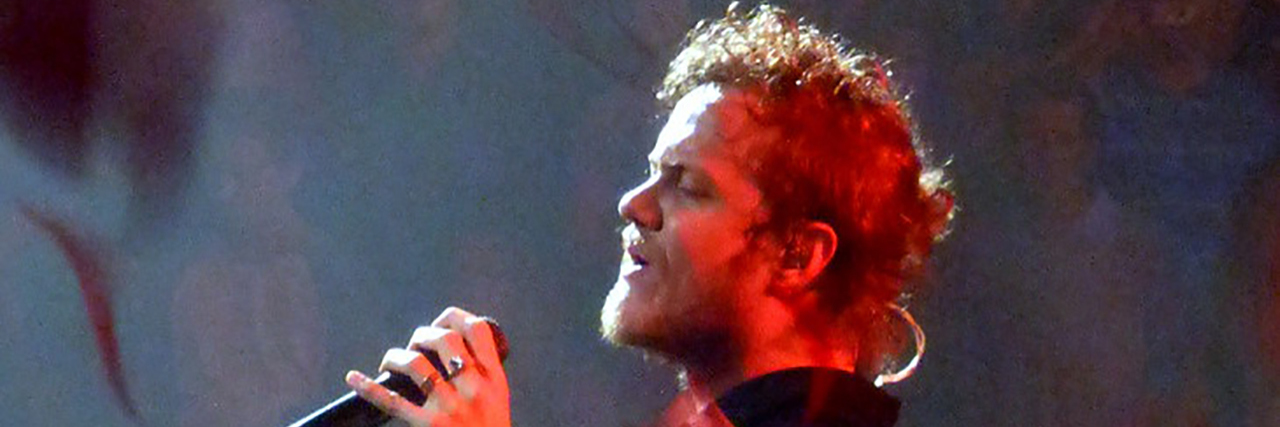 Imagine Dragons' Dan Reynolds Talks Depression at MSG Dan Reynolds sings onstage while wearing a blue or black outfit