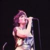 An older photo of Linda Ronstadt singing onstage with her band