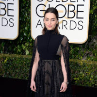 Emilia Clarke poses in a black gown on the Golden Globes red carpey