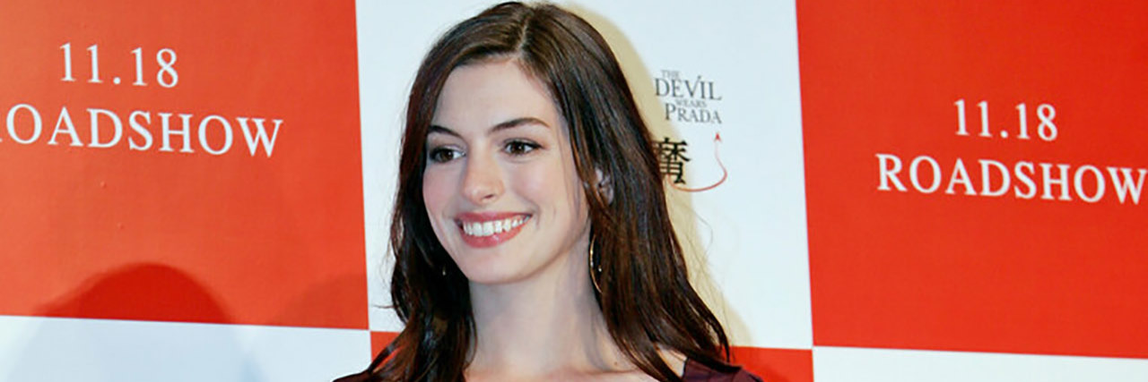 Anne Hathaway Sets Her Writings on Fire to Cope With Stress, Anxiety Anne Hathaway poses for the red carpet in a maroon dress
