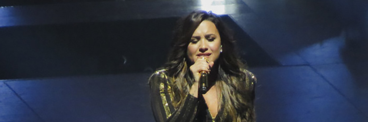 Demi Lovato Agrees to Enter Rehab After Overdose and Hospitalization Demi Lovato singing onstage while wearing a black and gold costume