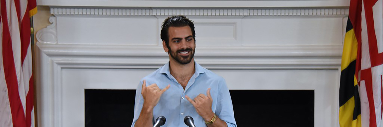 Nyle DiMarco signs at an event.