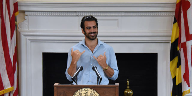 Nyle DiMarco signs at an event.