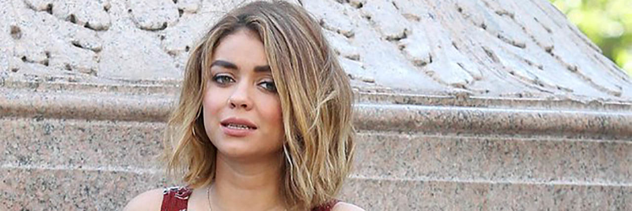 Sarah Hyland Says She Wore Hair Extensions to Conceal Hair Loss Sarah Hyland wears a red, blue and white dress on set of Modern Family