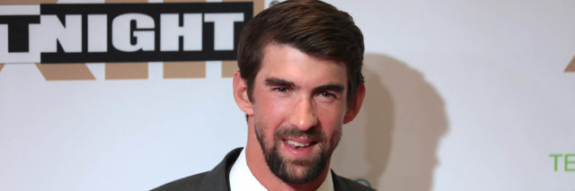 Michael Phelps poses on the red carpet in a suit