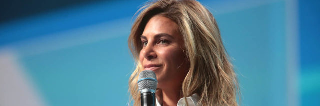 Jillian Michaels talks onstage while wearing a white blouse