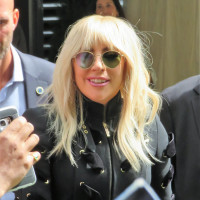 Lady Gaga wears a black jacket in front of a crowd