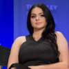 Ariel Winter wears a black dress while sitting on a panel