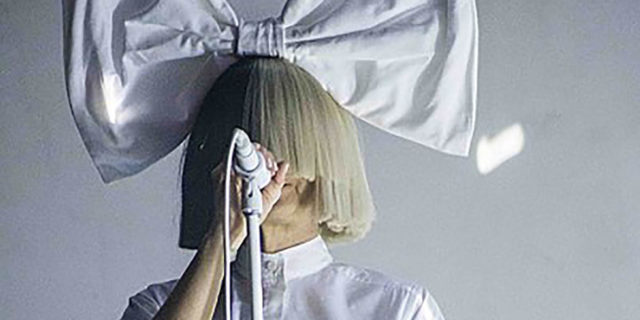Sia Opens Up About a Near Suicide Attempt in Rolling Stone Interview Sia singing onstage with a giant bow on her head