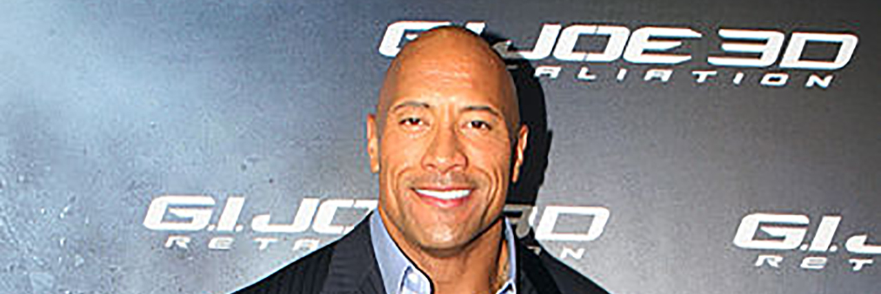 The Rock poses on the red carpet in a suit