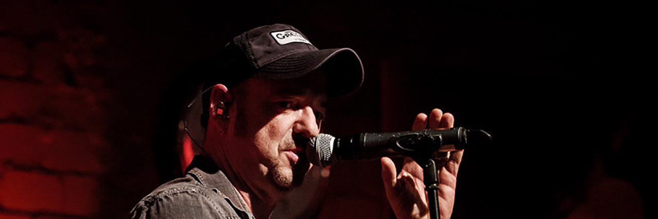 Bruce Springsteen's Metaphor for Suicidal Thoughts and Emotional Pain Bruce Springstein performs onstage in a poorly lit roon