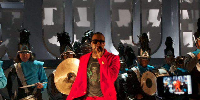 Kanye West performs in a red suit