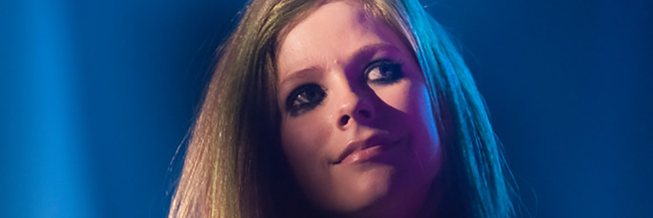 Avril Lavigne looks in front of a crowd at a concert