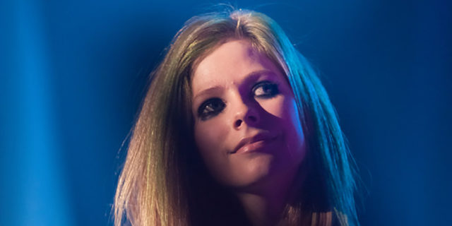 Avril Lavigne looks in front of a crowd at a concert