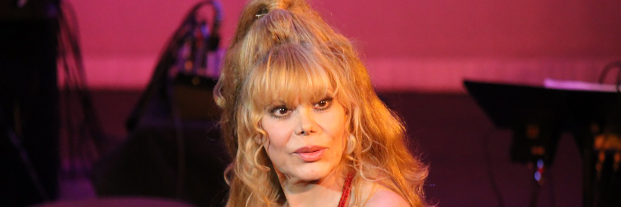 Singer Charo performs onstage ina red sequin dress