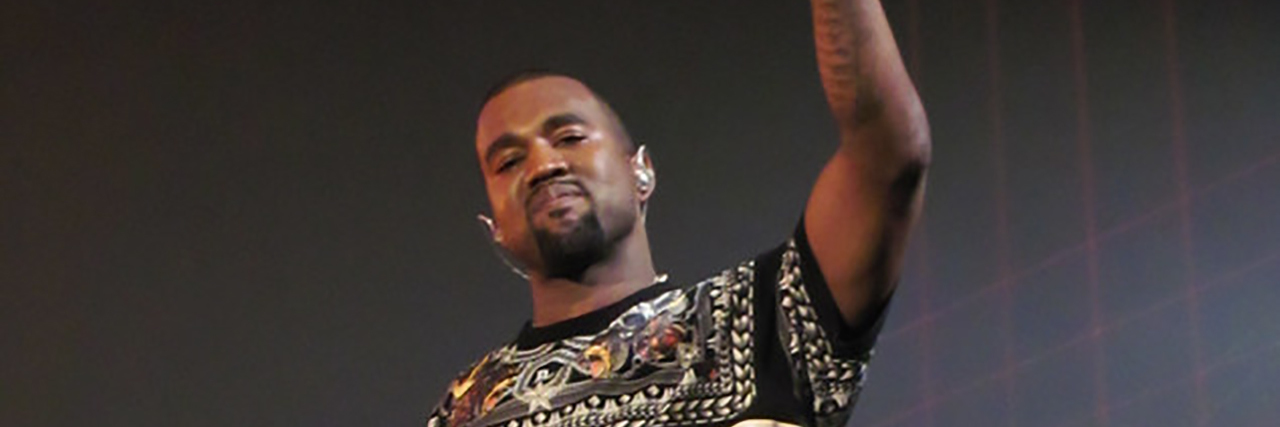 Kanye West posing while at a concert onstage