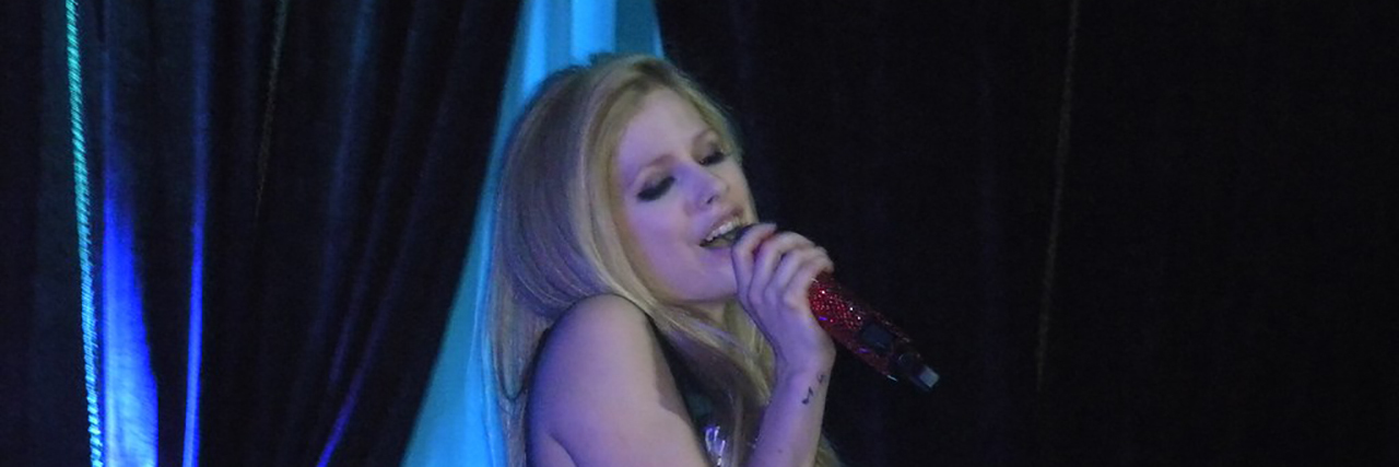 Avril Lavigne sings while wearing a black outfit