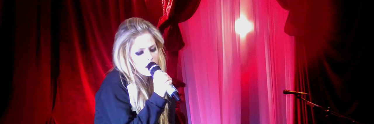 Avril Lavigne Releases New Song 'Head Above Water' About Lyme Disease Avril Lavigne sings while sitting down in a black ensemble