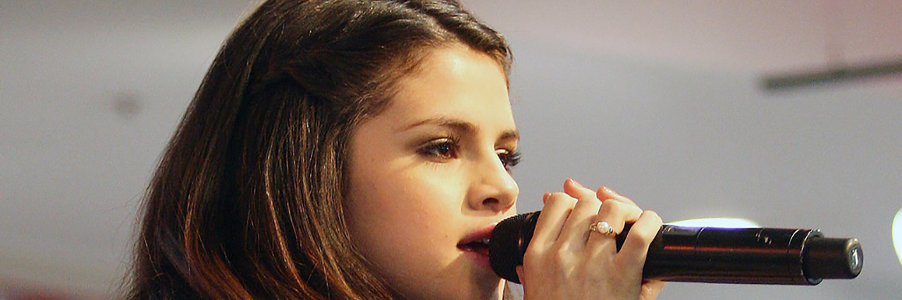 Selena Gomez's Hospitalization Shows How Illness Impacts Mental Health Selena Gomez looks straightahead while wearing a black ensemble