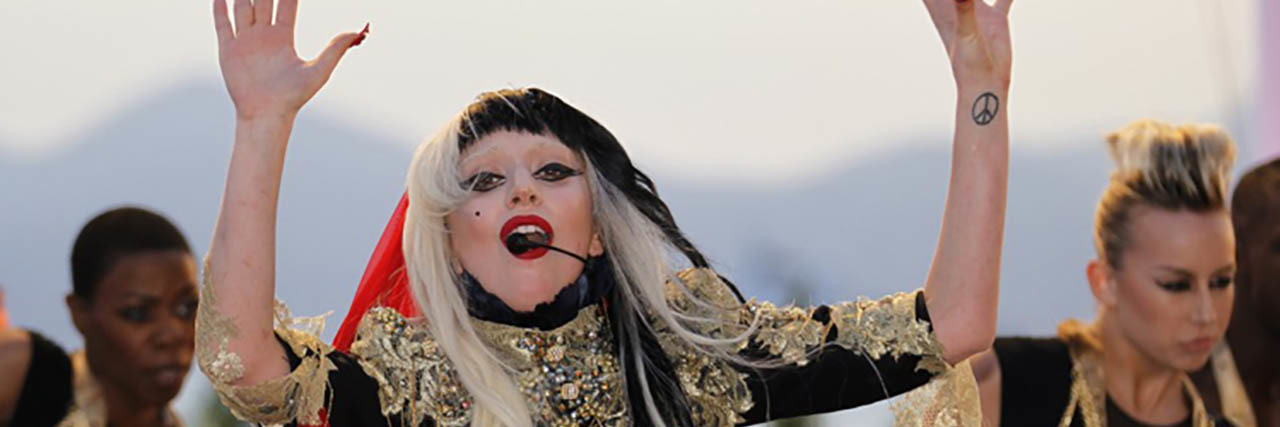 Lady Gaga Shares Open Letter About Her Experience With Mental Illness and PTSD Lady Gaga performs while wearing a gold, back and red ensemble