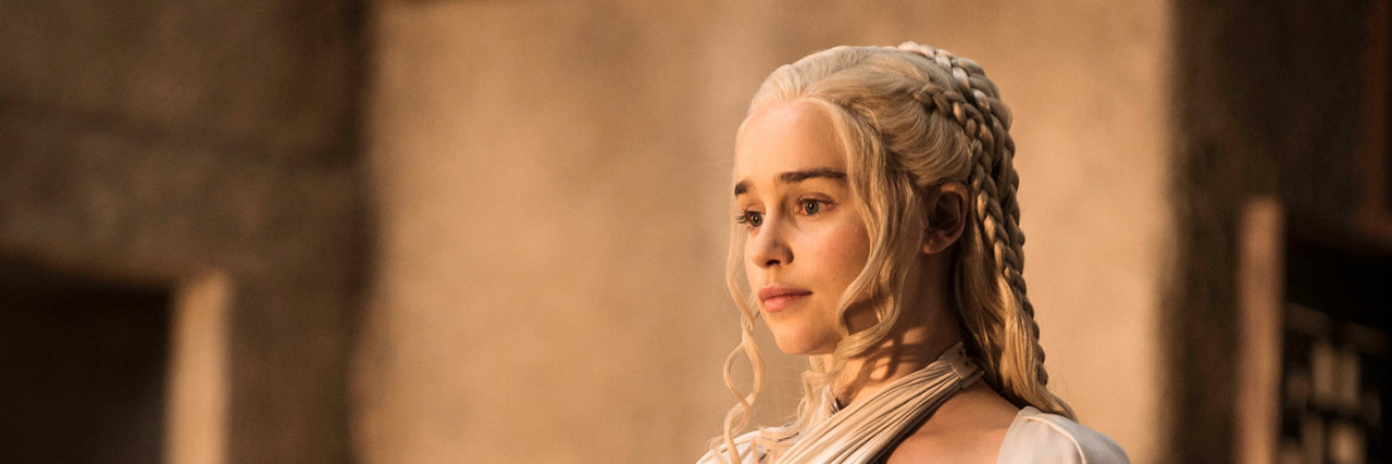 A still of Emilia Clarke onset of Game of Thrones in a white ensemble