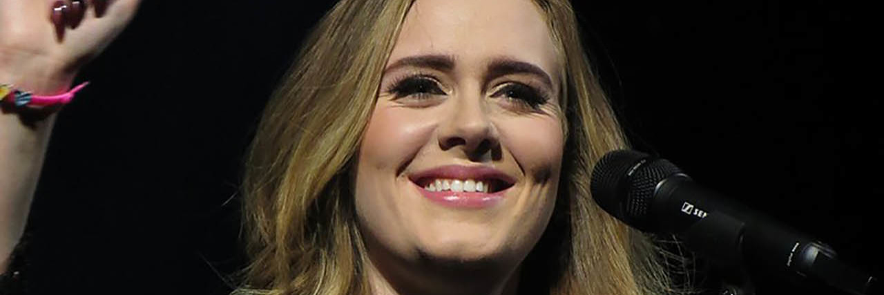 Adele Shares History of Postpartum Depression With Vanity Fair Adele performs onstage while wearing a black gown