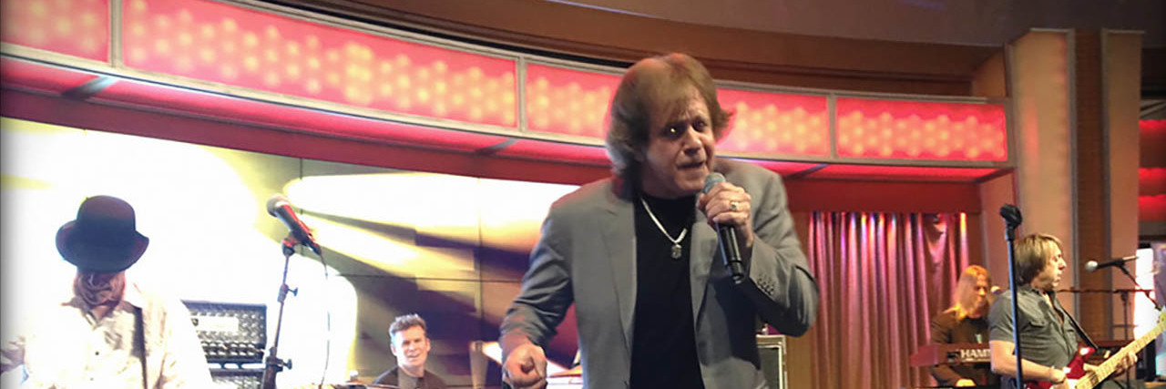 Eddie Money singing onstage with his band