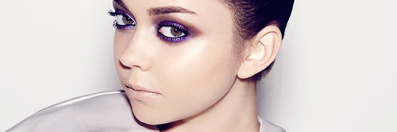 Sarah Hyland psoes in a lilac outfit with her hair pulled back