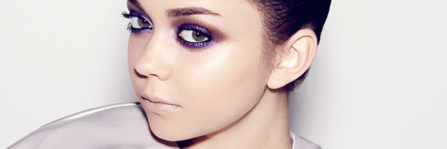 Sarah Hyland psoes in a lilac outfit with her hair pulled back