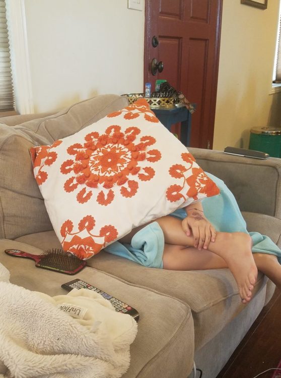 little girl covering face with a pillow