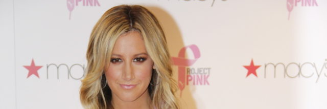 Ashley Tisdale in a t-shirt and jeans poses on the red carpet