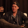 Avicci sitting down, wearing casual clothing, and speaking to an interviewer
