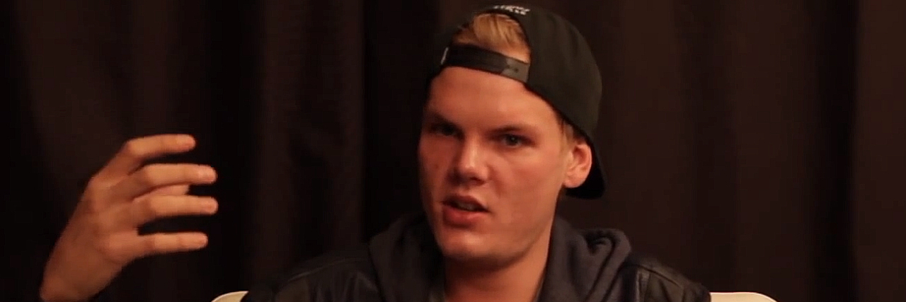 Avicci sitting down, wearing casual clothing, and speaking to an interviewer
