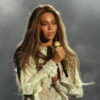 Beyonce performs onstage in a light creme outfit