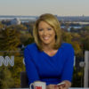 Brooke Baldwin smiles while wearing a blue dress at her CNN desk