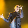 Chester Bennington sings onstage in a black outfit