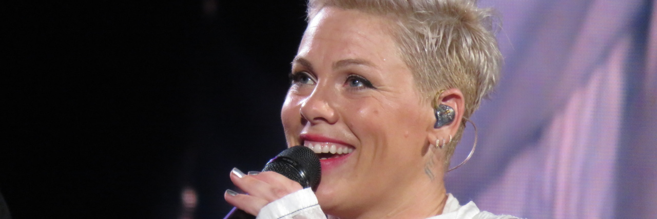 Pink performs onstage in a white outfit