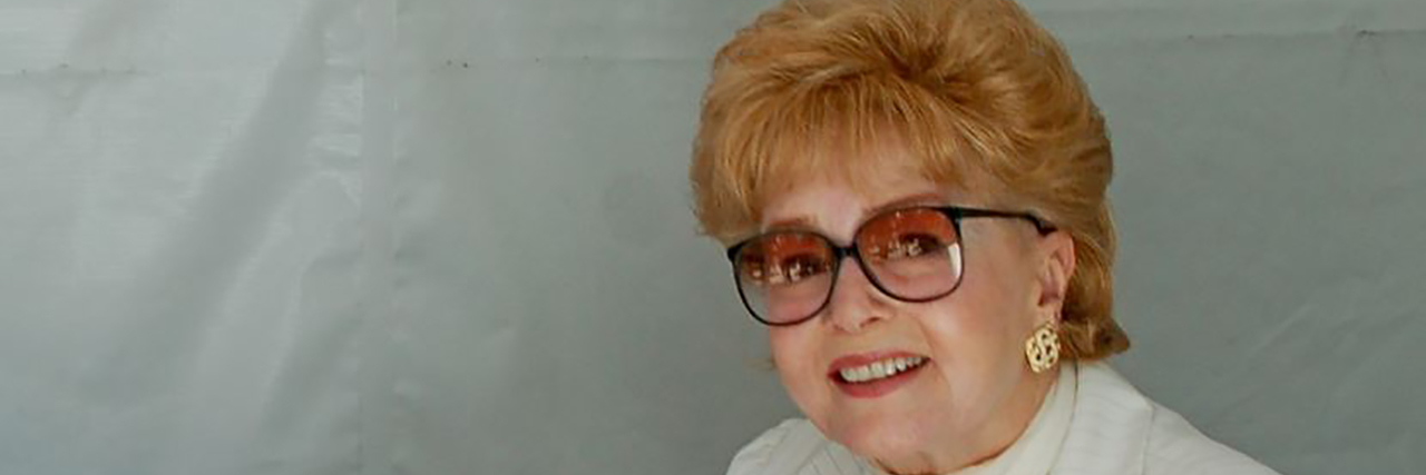 Debbie Reynolds to Receive Honorary Oscar for Work in Mental Health Debbie Reynolds signs a book while looking at the camera