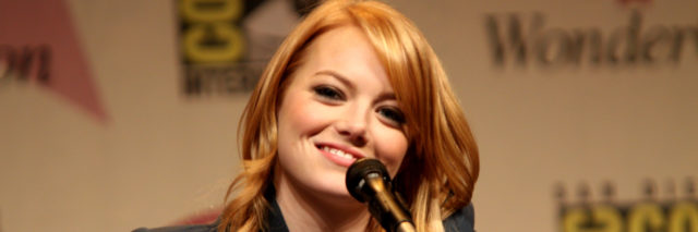 Emma Stone smiles at the audience while on a panel.