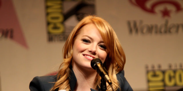 Emma Stone smiles at the audience while on a panel.