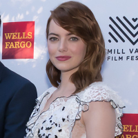 Emma Stone in a black and white dress poses on the red carpet