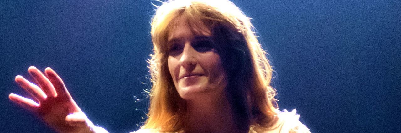 Florence Welch on Eating Disorder Recovery and Addiction Florence Welch reaches for something in the distance while performing onstage