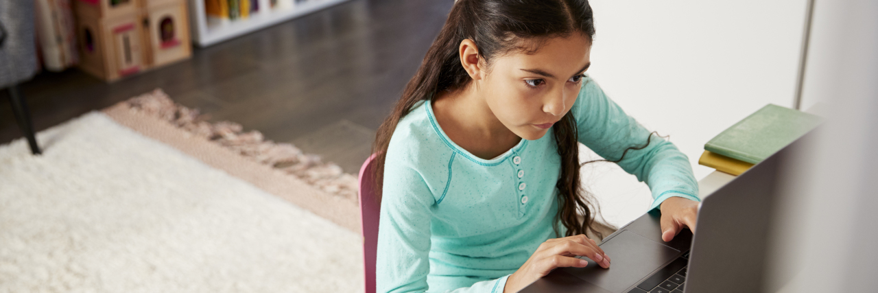 Continuity in Special Education Programs During the COVID-19 Pandemic Girl doing online school or therapy on her laptop.