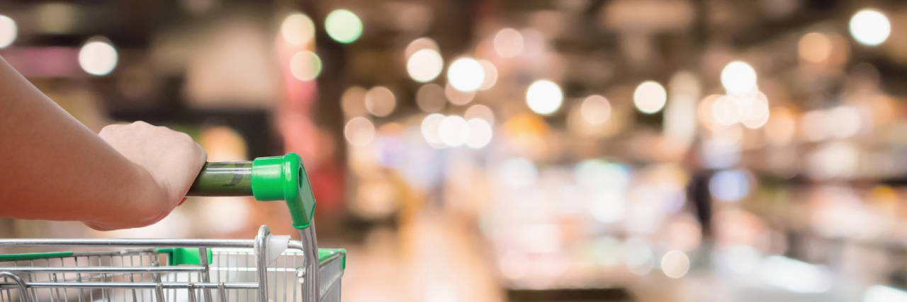 'Essential Items' Policing Is Harmful to My Eating Disorder Recovery hand holding a grocery cart