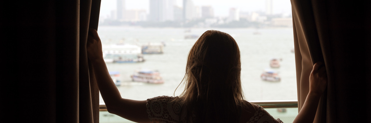 Lessons COVID-19 Can Teach Us About Disability Accommodations Woman opening window curtains.