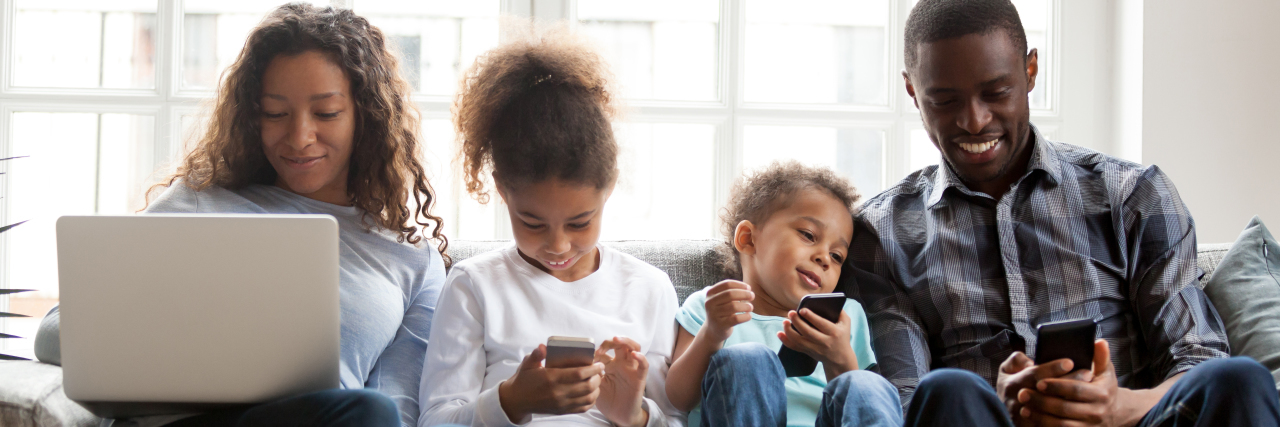 Personal Space and Privacy for Family Members During COVID-19 Pandemic Family using devices, sitting together.