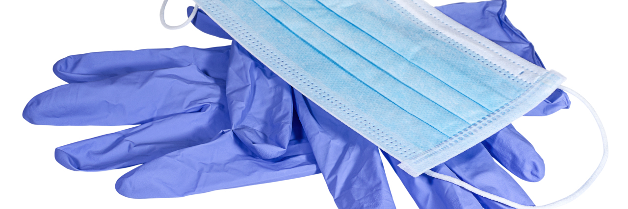 Amazon Blocks Medical Supply Purchases During COVID-19 Pandemic Blue medical mask and gloves on white background.