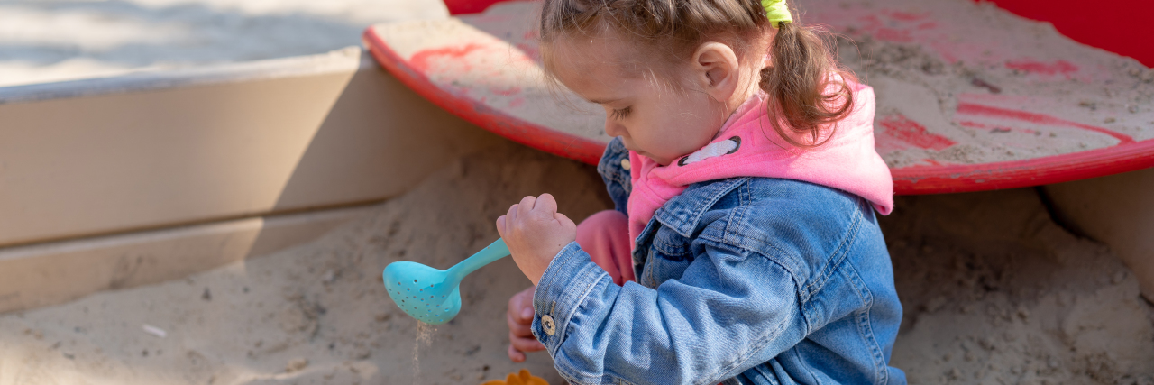 Girl playing in sandbox.