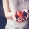woman holding a red heart in her hands