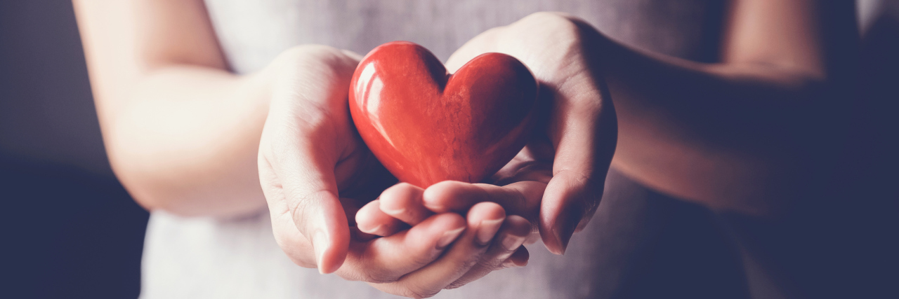What a Therapist Wants You to Know If Life Feels Impossible woman holding a red heart in her hands